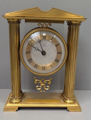 une image représentant une horloge dorée dont le cadran est orné de chiffres romains