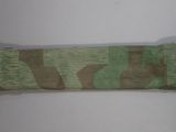 a green and brown camouflage cloth on a white surface