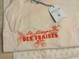the t - shirt is white and has a red design on it
