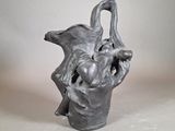 une sculpture représentant un vase dans lequel se trouvent un oiseau et un bébé