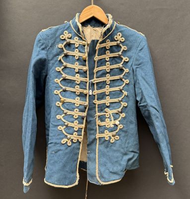 une veste militaire bleue avec des boutons dorés, suspendue à un cintre