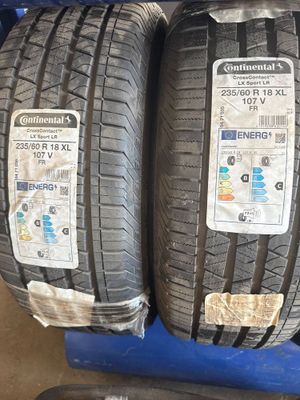 deux pneus sont empilés l'un sur l'autre sur un chariot bleu