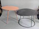 two tables with different colors on them in front of a white backdrop