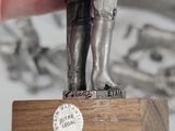 a silver statue of a man holding a coin in his hand