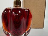 un flacon de parfum posé sur une table à côté d'une boîte
