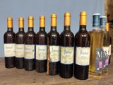 several bottles of wine are lined up on a wooden table