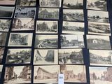 Plusieurs vieilles cartes postales, de types et de tailles variés, sont posées sur une table