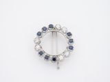 un gros plan sur une broche en forme de losange bleue et blanche
