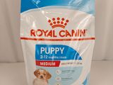 un sac de croquettes Royal Canin pour chiots posé sur une surface blanche