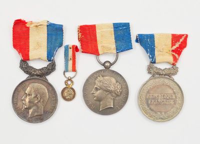 trois médailles et une médaille sur une surface blanche