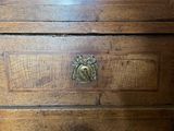 a wooden dresser with a brass knob on it