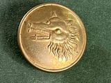 une pièce d'or représentant un lion, posée sur un fond vert
