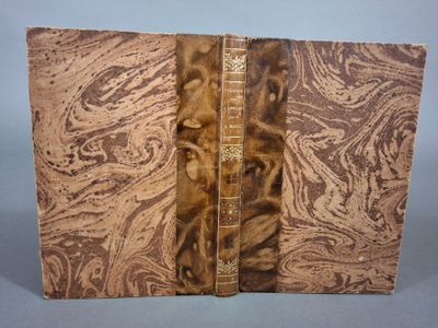 un vieux livre à la couverture brune posé sur une table