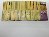 a pile of yellow pokemon cards sitting on top of a white table