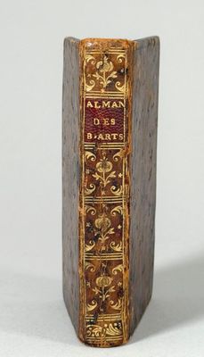un vieux livre posé sur une table à côté d'un mur blanc