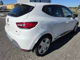 the rear end of a white car parked in a parking lot