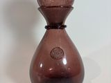 a brown glass vase sitting on a white surface