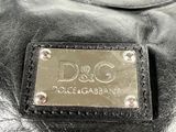 black leather handbag with a metal plate that says dolce gabbana