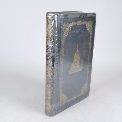 un vieux livre posé sur une table blanche à côté d'un mur blanc