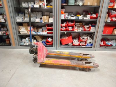 un chariot élévateur dans un entrepôt où les rayonnages sont remplis de cartons