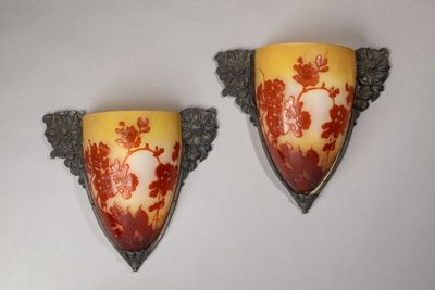 two wall sconces that have red and yellow designs on them