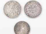 three different types of silver coins on a white surface