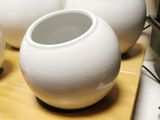 three white vases sitting on top of a wooden cutting board