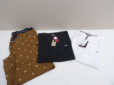 trois paires de pyjamas et de t-shirts pour homme posés sur une table