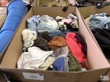 a cardboard box filled with clothes and a stuffed animal