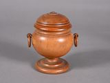 a small wooden urn with a lid on a table