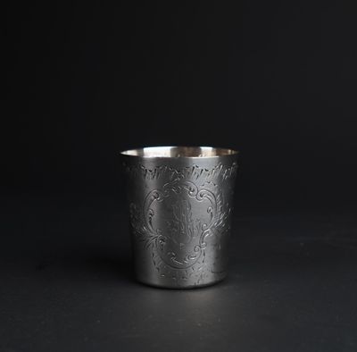 a close up of a silver cup on a black surface