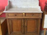 une armoire en bois avec un plateau en marbre, à côté d'une commode