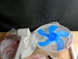 une table sur laquelle se trouvent un ventilateur et d'autres objets
