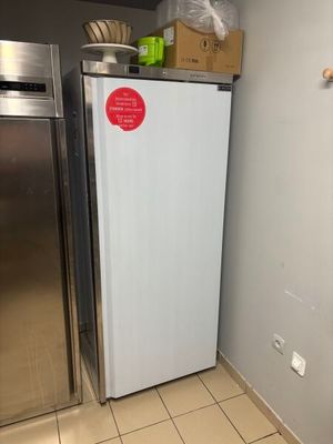 a refrigerator in the corner of a kitchen with a box on top of it