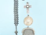 an assortment of silver jewelry on a blue background