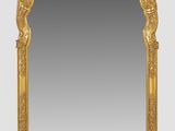 a gold framed mirror with a decorative design on it