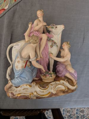 une figurine représentant une femme et deux enfants sur une vache