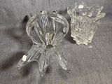 une paire de bougeoirs en verre transparent posés sur un tissu gris