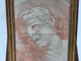 painting of a man ' s head in a gold frame on a wooden easel