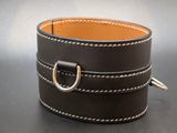 brown leather cuff bracelet with a silver ring on a black surface