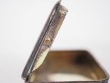 a small metal box with a lid that is open