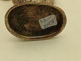 a silver vase with a label on it sitting on a table