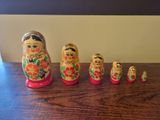 five matry dolls lined up on a wooden table