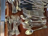 de nombreuses cuillères et fourchettes posées sur un plateau posé sur une table