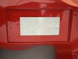 a close up of a red motorcycle with a name plate