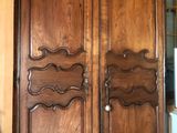 a large wooden armoire in the corner of a room
