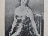 une vieille photo en noir et blanc représentant une femme en robe, assise sur une chaise