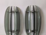 two oval mirrors on the wall next to each other