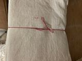 une pile de linge de lit plié posée sur un lit