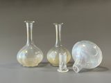trois vases en verre posés l'un à côté de l'autre sur une table
